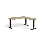 Lavoro Advance Corner triple-motor standing desk, black frame and natural oak desktop; pictured size representative
