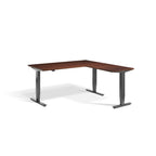 Lavoro Advance Corner triple-motor standing desk, dark grey frame and natural dijon walnut desktop; pictured size representative